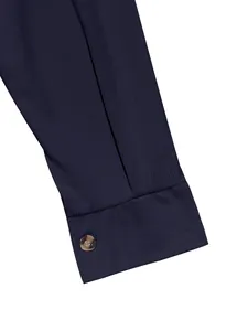 Close-up detail of the navy blue corduroy fabric texture and sleeve cuff with a button.
