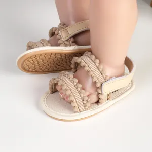 Detailansicht von Baby-Lauflernsandalen mit Bommelbesatz und Klettverschluss-Detail