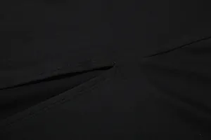 Μακροεντολή λεπτομέρεια με τις ραφές υψηλής ποιότητας και το σκίσιμο σε μαύρο φόρεμα
