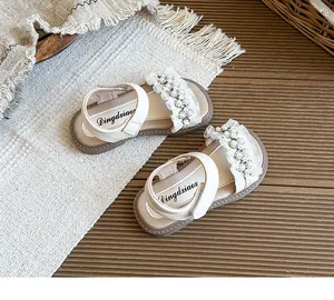 Detailed view of girl's princess sandals with lace frills and pearl accents