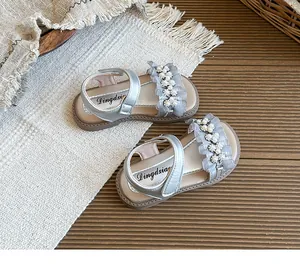 Detailed top view of silver girls' princess sandals with pearl flower and ruffle accents
