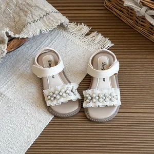 Elegant girl's cream-white pearl sandals with ruffle detail for summer beach outings.