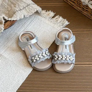 Elegant silver girl's summer sandals decorated with pearl flowers and soft ruffles