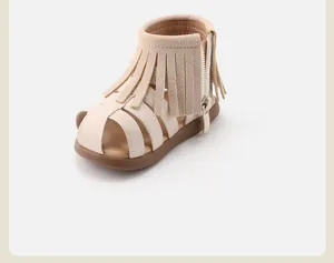 Detail view of girls' Roman sandals with stylish fringes and side zipper closure.