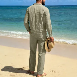 Rear view of a man wearing a sage green linen shirt and trousers set on a sunny beach