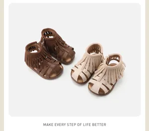 A detailed view of children's fringe Roman sandals available in brown and beige.