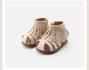 Close-up detail of beige toddler fringe sandals with Roman style and soft soles.