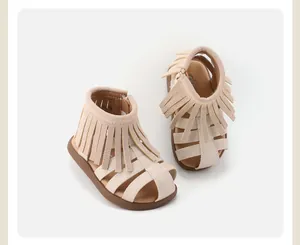 Top-down view of children's cream fringe sandals with soft non-slip brown soles