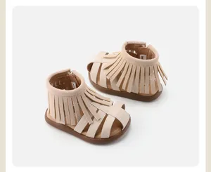 Toddler girls stylish beige Roman sandals with fringe detail and soft flexible brown sole.