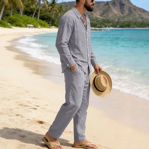 Men's grey linen long-sleeve shirt and trousers set worn on a sunny beach