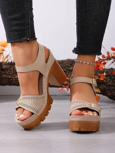 Detail von beigen Plateausandalen mit Blockabsatz, Lasercut-Muster und Schnallenriemen