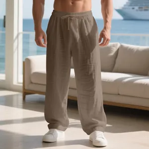 Pantalon ample en lin pour homme avec cordon de serrage, présenté dans un décor bord de mer.