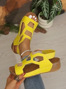 Detailansicht der gelben Keilsandaletten mit Cut-out-Design und Gummizug