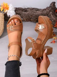 Nahaufnahme brauner Plateau-Sandalen mit klobigem Absatz, Cut-out-Muster und Knöchelriemen