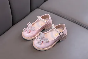 Vista detallada de zapatos de princesa rosas con mariposa de diamantes y correa de perlas