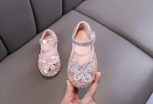 Gros plan de chaussures de princesse roses à paillettes pour filles avec motif papillon.