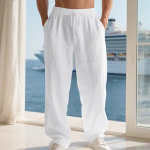 Gros plan sur un pantalon en lin blanc pour homme avec taille à cordon et coupe ample