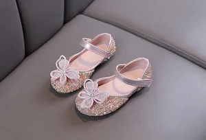 Gros plan de chaussures de princesse roses étincelantes pour filles avec papillon