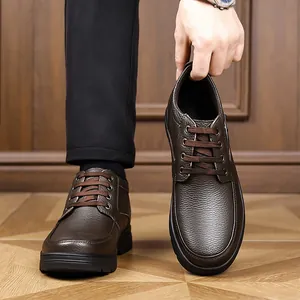 Detail view of premium brown leather men's snow boots with durable thick black soles.