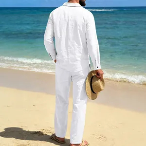 Vista trasera de un hombre con camisa de lino blanco y conjunto de pantalones en una playa soleada