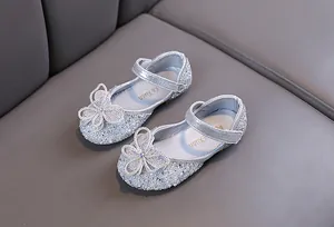 Vue détaillée de chaussures de princesse argentées étincelantes pour filles avec nœud