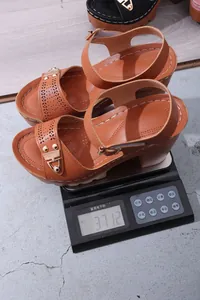 Detailansicht mit Gewicht von braunen Plateau-Sandalen mit Blockabsatz auf einer Waage