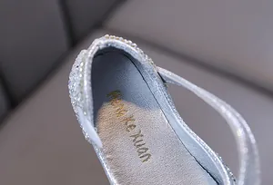Détail de chaussure de princesse argentée à strass pour fille avec logo sur la semelle
