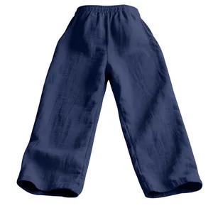 Détail d'un pantalon en gaze de coton bleu marine, coupe ample et tissu texturé.