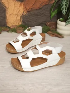 Detailansicht der weißen Freizeit-Keilsandalen mit Lochmuster und Gummiband