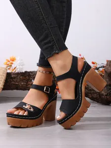 Detailansicht schwarzer Sandalen mit klobigem Absatz und Plateausohlen in Holzoptik