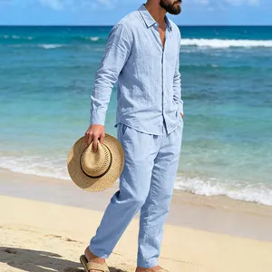 Detalle de conjunto de lino azul para hombre usado por un modelo en una playa soleada.