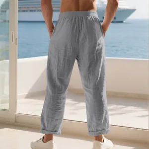 Vue arrière détaillée d'un pantalon ample en lin gris pour homme face à la mer.