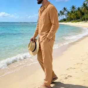 Vista lateral de un hombre con un conjunto de camisa y pantalón de lino albaricoque en la playa
