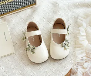 Elegante cremeweiße Mädchen-Mary-Jane-Schuhe mit schicker grün karierter Schleife und Riemen.