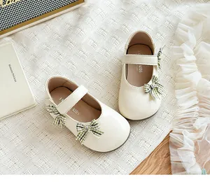 Detailansicht der beigen Mädchen Mary Jane Schuhe mit grün karierten Schleifen