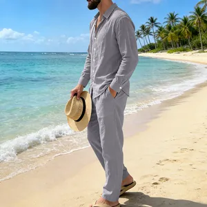 Vista lateral del conjunto casual de camisa y pantalón gris para hombre en la playa