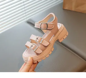 Gros plan sur les sandales à plateforme roses pour filles avec boucles et semelle crantée.