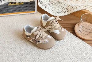 Vue de dessus de baskets beiges pour enfants avec de jolis nœuds à carreaux détaillés
