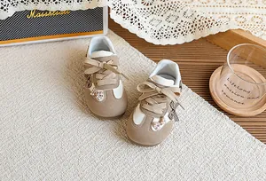 Détail rapproché des baskets GAT pour enfants avec des nœuds à carreaux marron chic