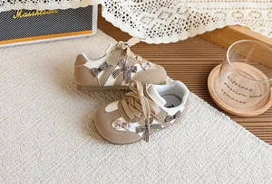 Gros plan sur des baskets beiges pour filles avec nœuds à carreaux et fermeture scratch