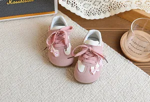 Vue détaillée des nœuds roses et des lacets sur ces baskets pour petites filles