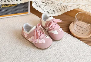 Détail de baskets roses pour enfants avec de jolies décorations de nœuds à carreaux
