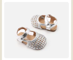 Detailansicht von silbernen geflochtenen Babylauflernschuhen mit weicher Sohle und Klettverschluss.