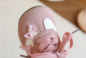 Zoom sur le nœud rose et la texture en daim des baskets de style allemand pour enfants.