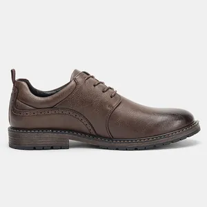 Detailed side view showing texture of brown burnished men's leather shoes with brogue design
