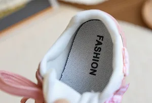 Gros plan de baskets roses pour filles avec doublure douce et détail de nœud à carreaux