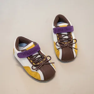 Retro-Kinder-Sneaker mit weißem Mesh-Obermaterial und lila Klettverschlussband