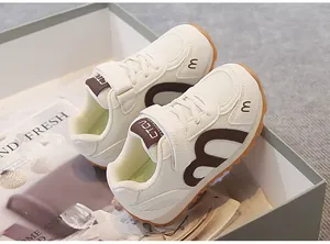 Detailed view of the breathable mesh children's sneakers in white and brown finish
