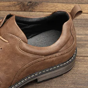 Close-up detail of brown men's leather shoe with brogue stitching and heel tab