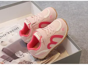 Detail view of pink breathable children's sneakers with secure velcro strap closure